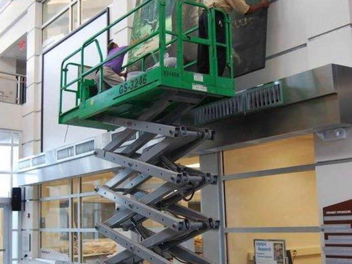 Several banners are being hung in the museum's Harvest Foundation Great Hall