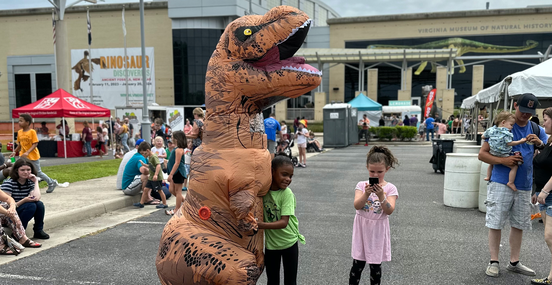 Costumed dinosaur with festival goer